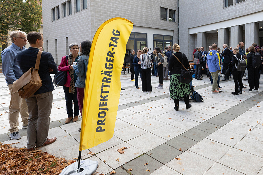 Projektträger Tag 2024 Teilnehmende im Austausch vor dem Gebäude